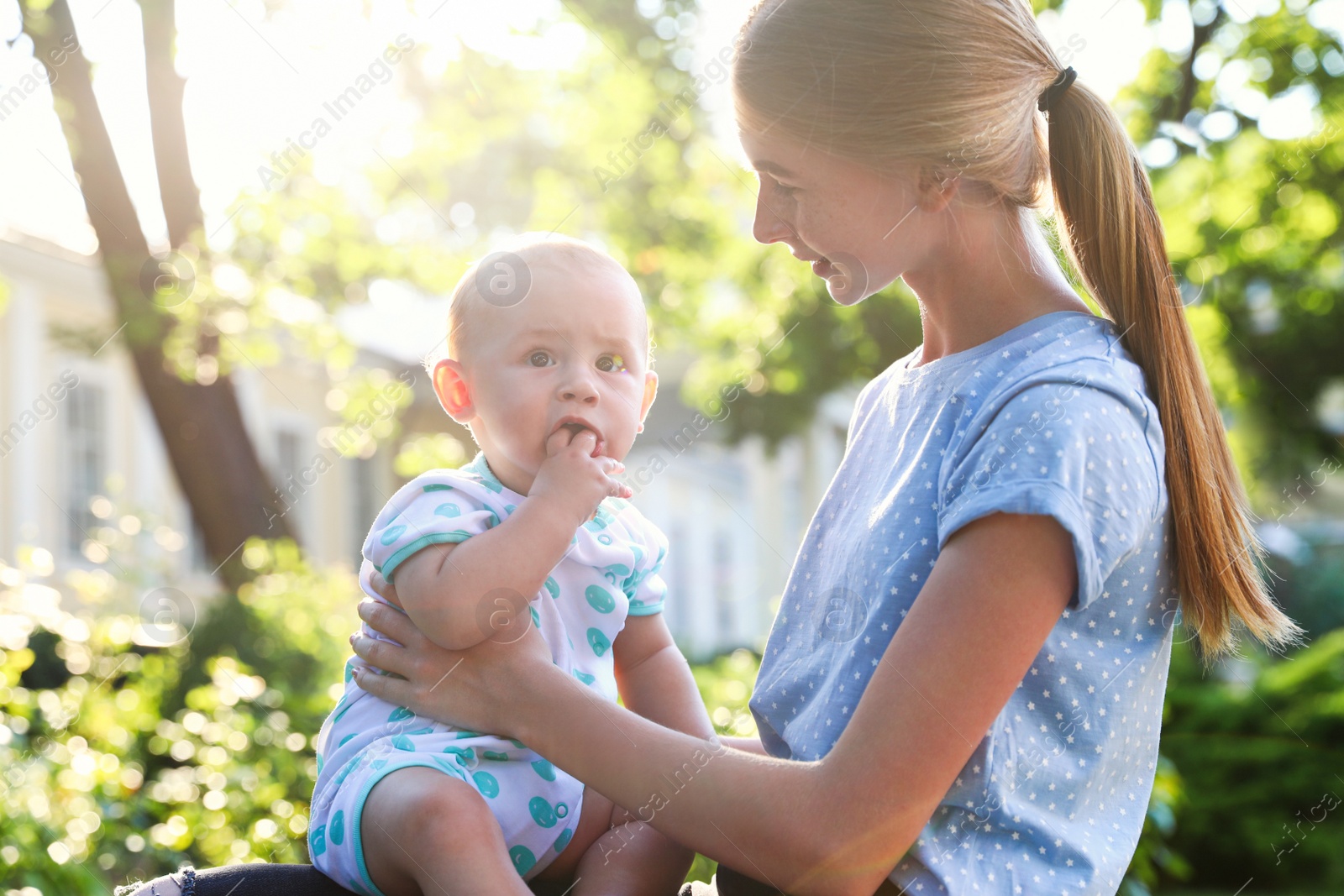 Photo of Teen nanny with cute baby outdoors on sunny day