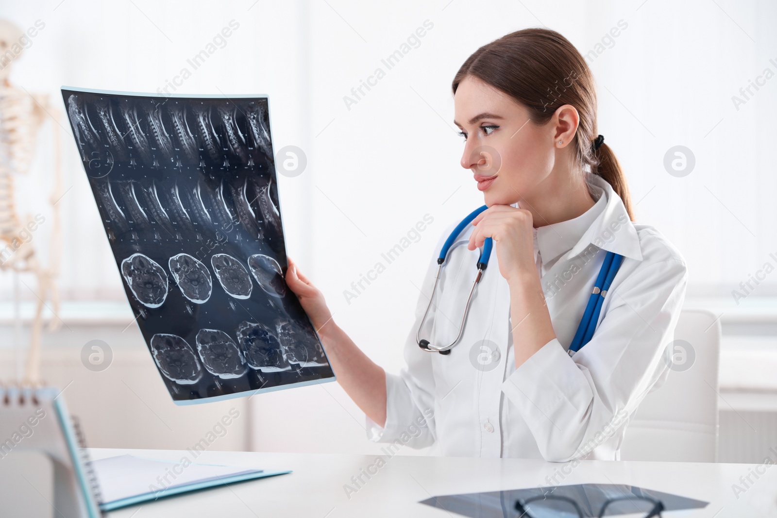 Photo of Orthopedist examining X-ray picture at desk in clinic