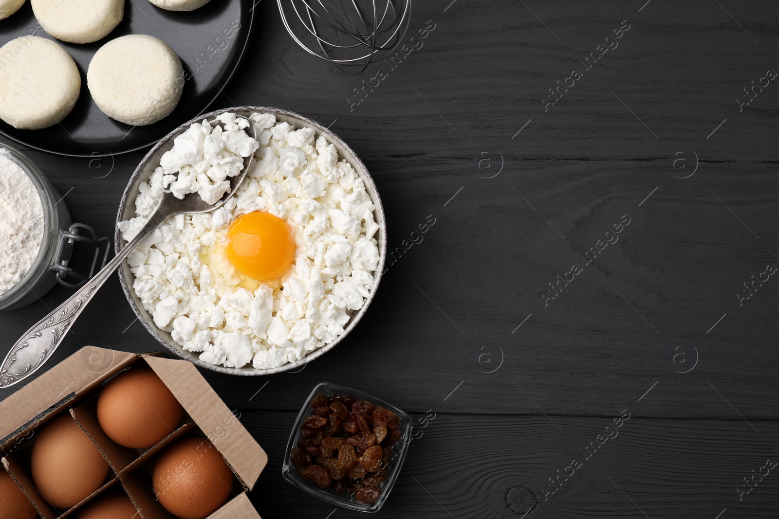 Photo of Uncooked cottage cheese pancakes and different ingredients on grey wooden table, flat lay. Space for text