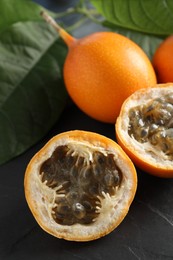 Photo of Delicious ripe granadillas on black table, closeup