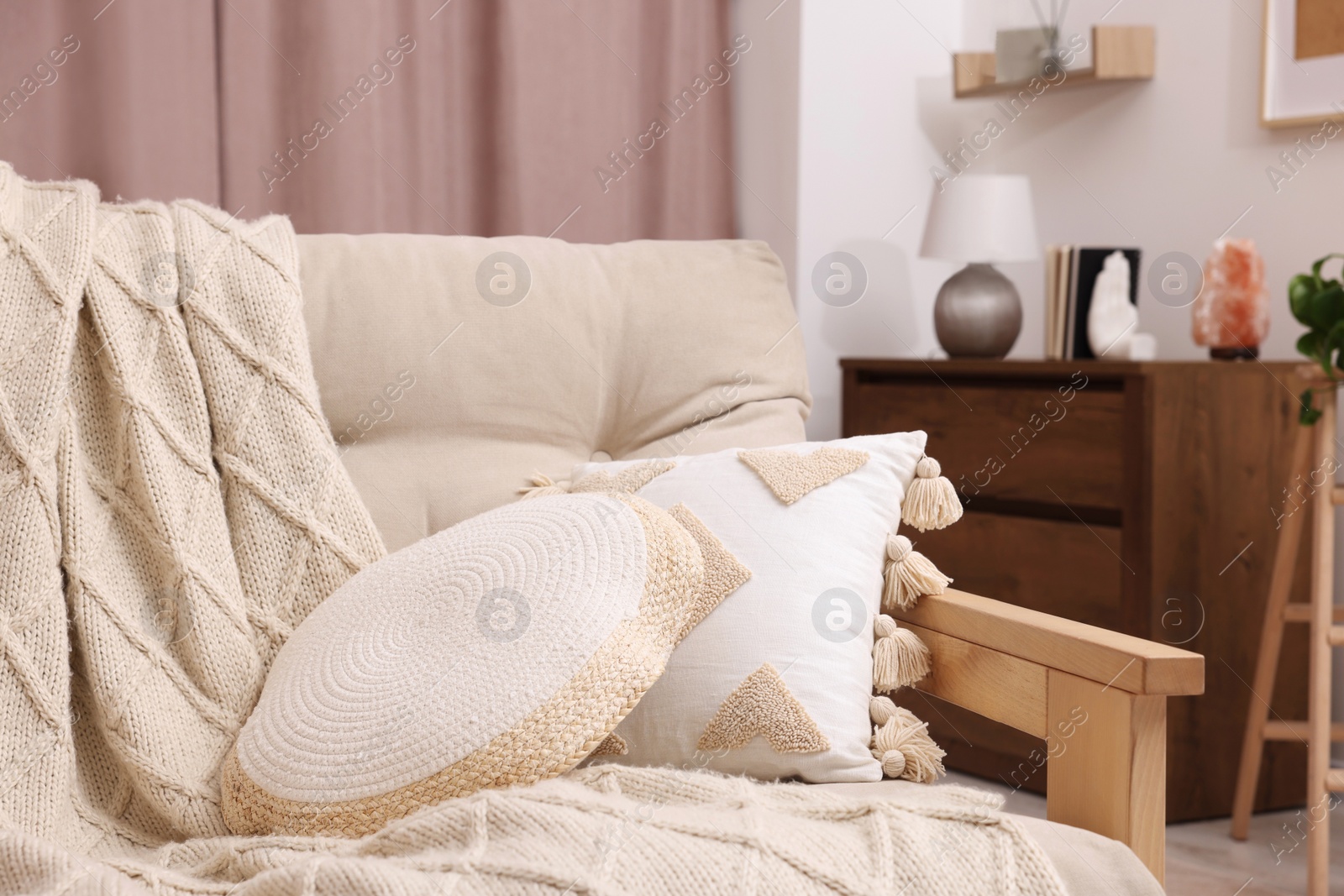 Photo of Comfortable sofa, cushions and blanket in cozy room. Interior design