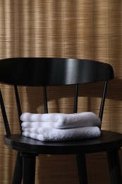 Stacked soft towels on black chair indoors