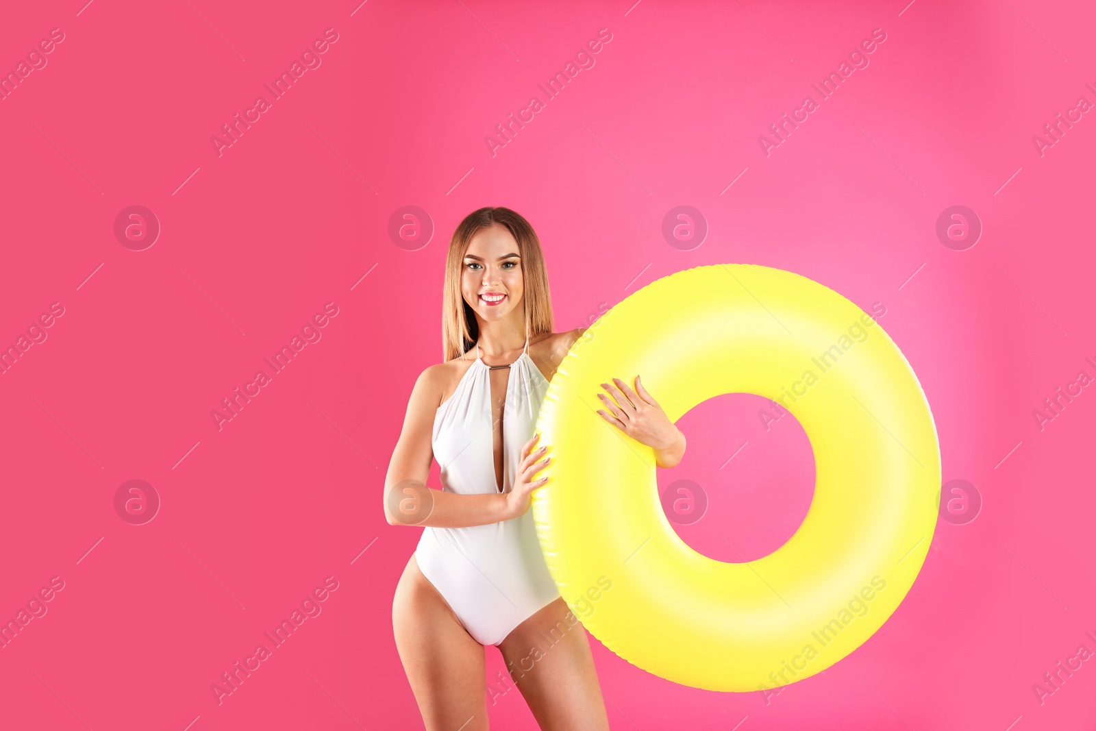 Photo of Pretty sexy woman in stylish bikini with inflatable ring on color background