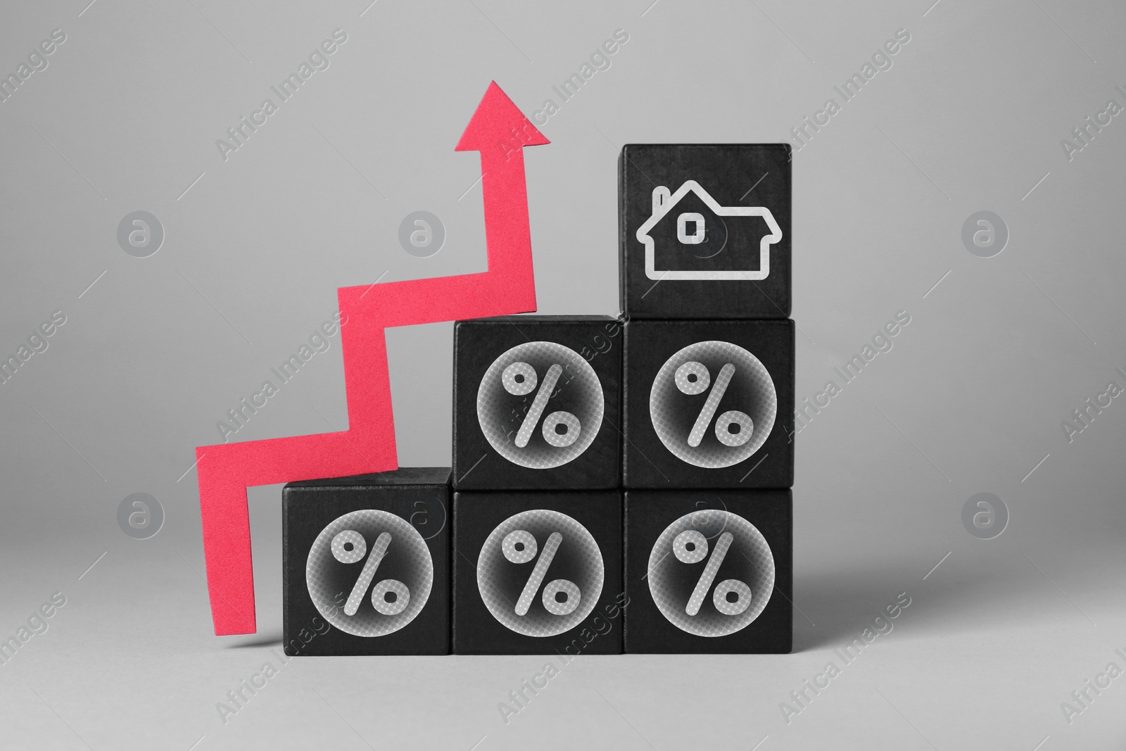 Image of Mortgage rate rising illustrated by upward arrow, black cubes with percent signs and house icon on gray background