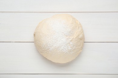 Fresh yeast dough with flour on white wooden table, top view