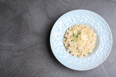 Photo of Delicious risotto with cheese on grey table, top view. Space for text