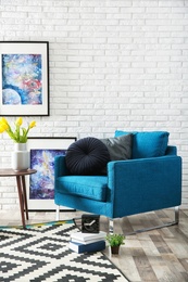 Photo of Modern living room interior with comfortable armchair near brick wall. Space for text