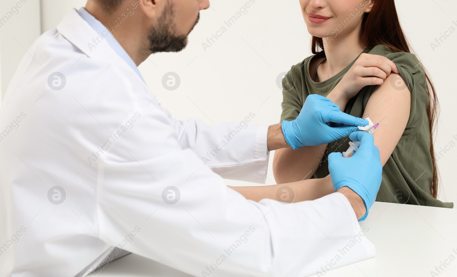 Photo of Doctor giving hepatitis vaccine to patient in clinic