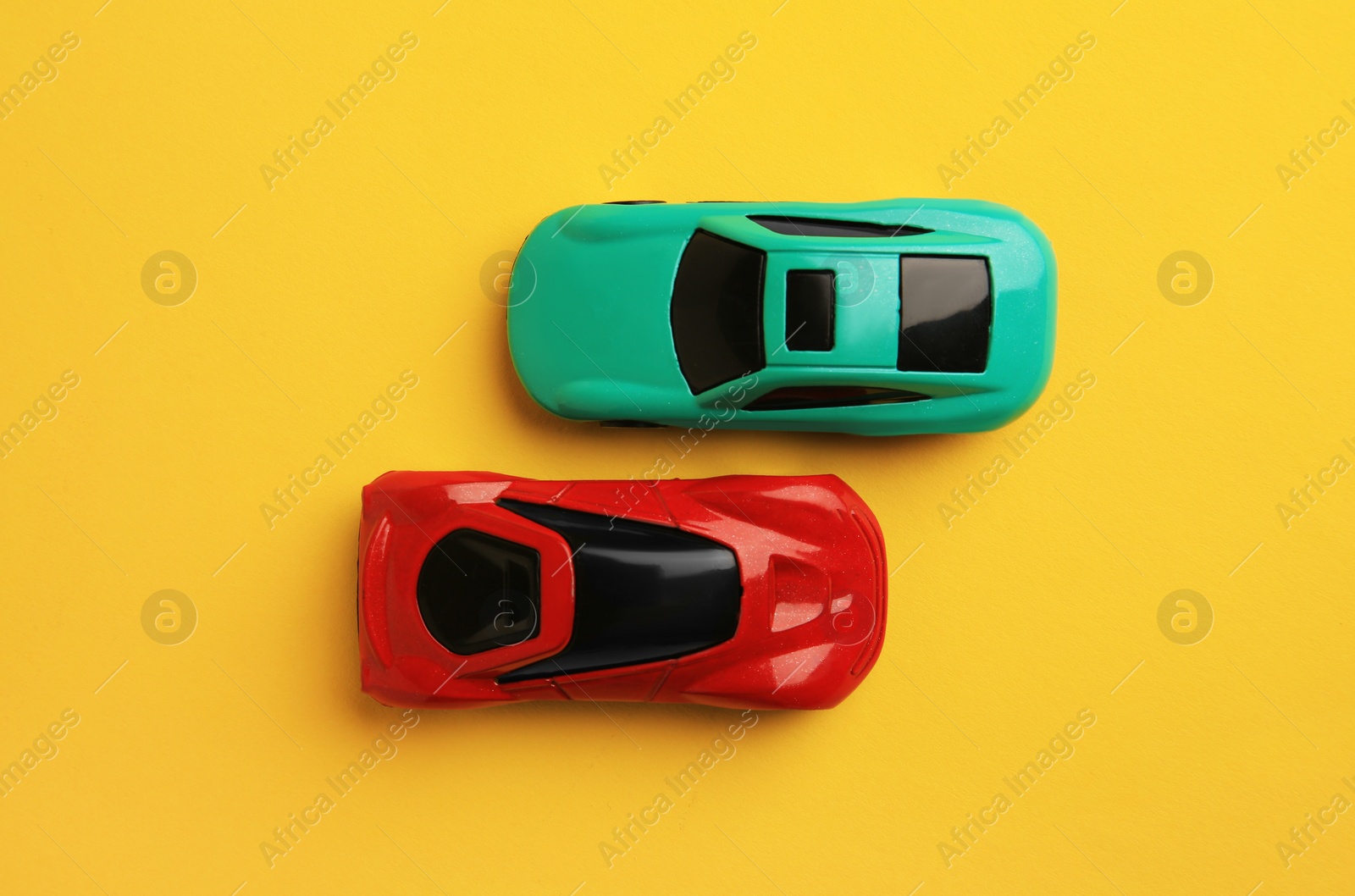 Photo of Bright cars on yellow background, flat lay. Children`s toys