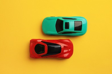 Photo of Bright cars on yellow background, flat lay. Children`s toys