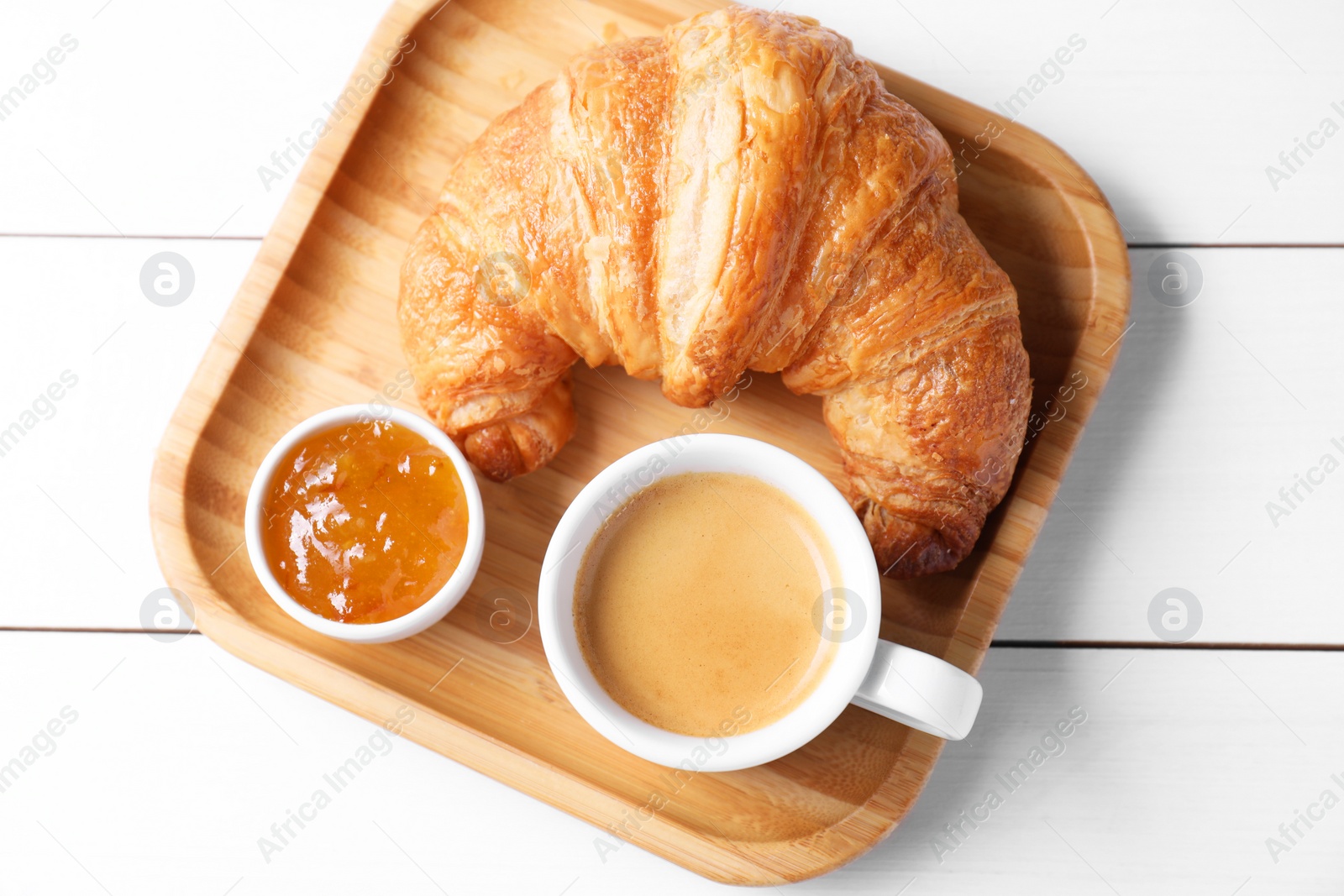 Photo of Fresh croissant, jam and coffee on white wooden table, top view. Tasty breakfast