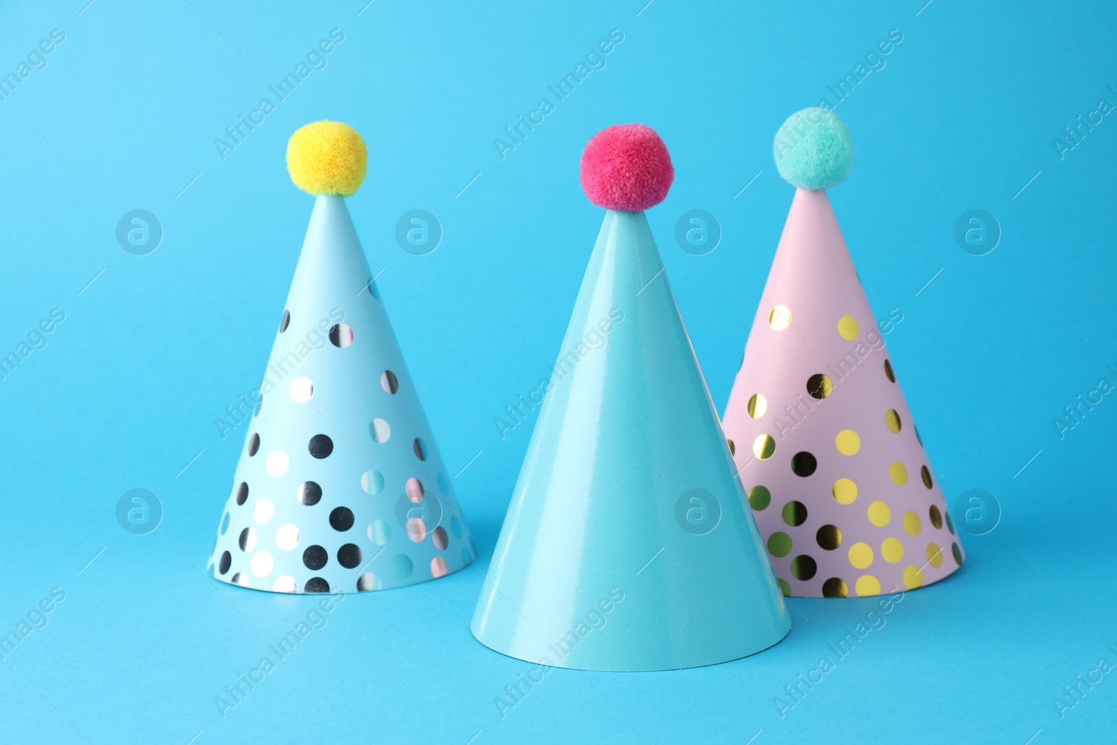 Photo of Colorful party hats on light blue background