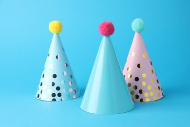 Colorful party hats on light blue background