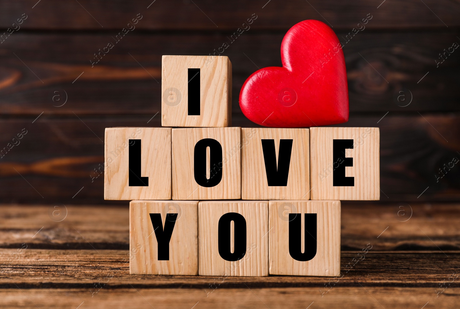 Photo of Cubes with words I Love You and red heart on wooden table