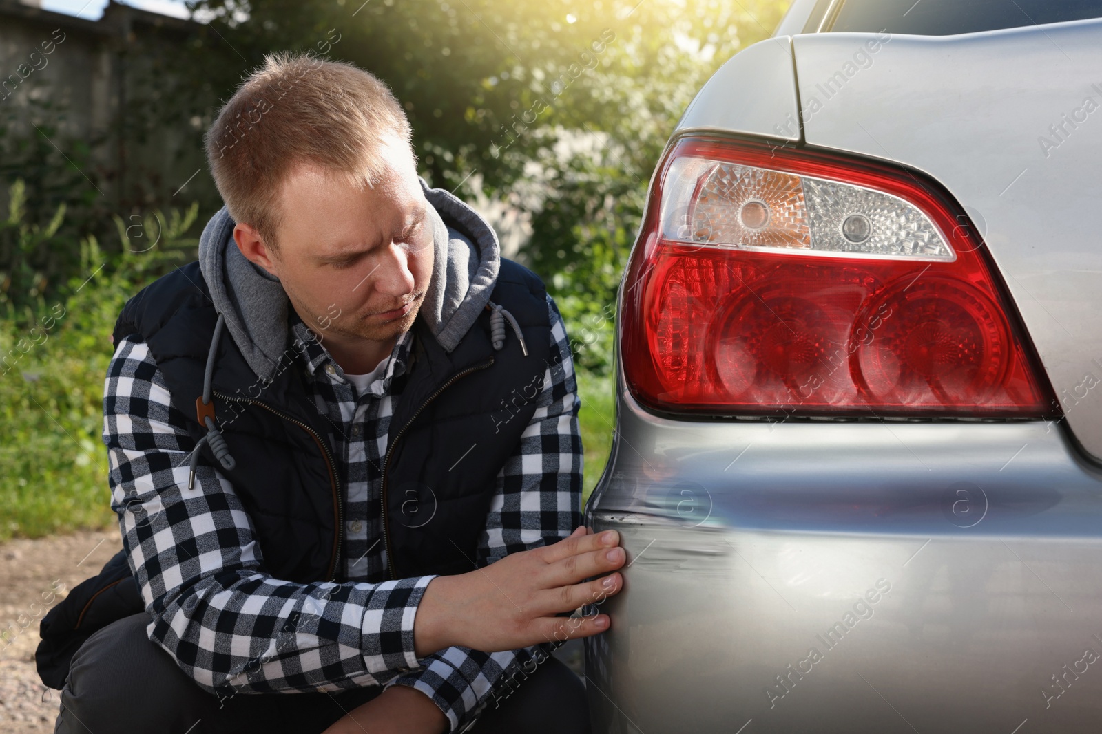 Photo of Stressed man near car with scratch outdoors