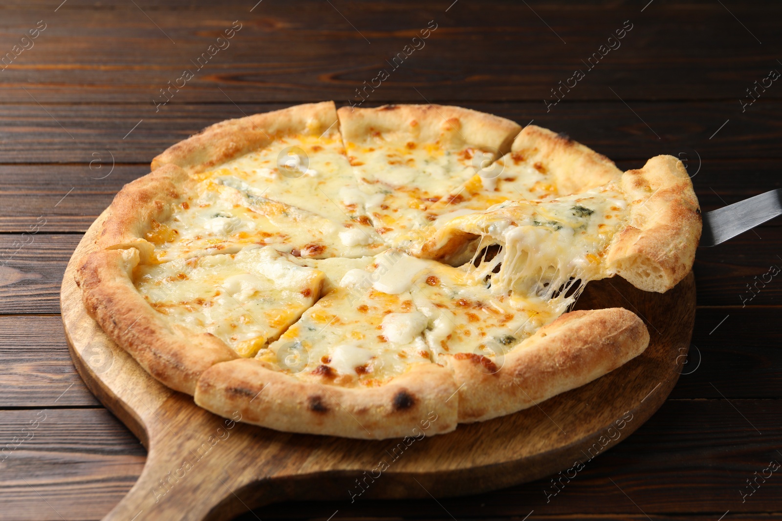 Photo of Taking piece of delicious cheese pizza at wooden table