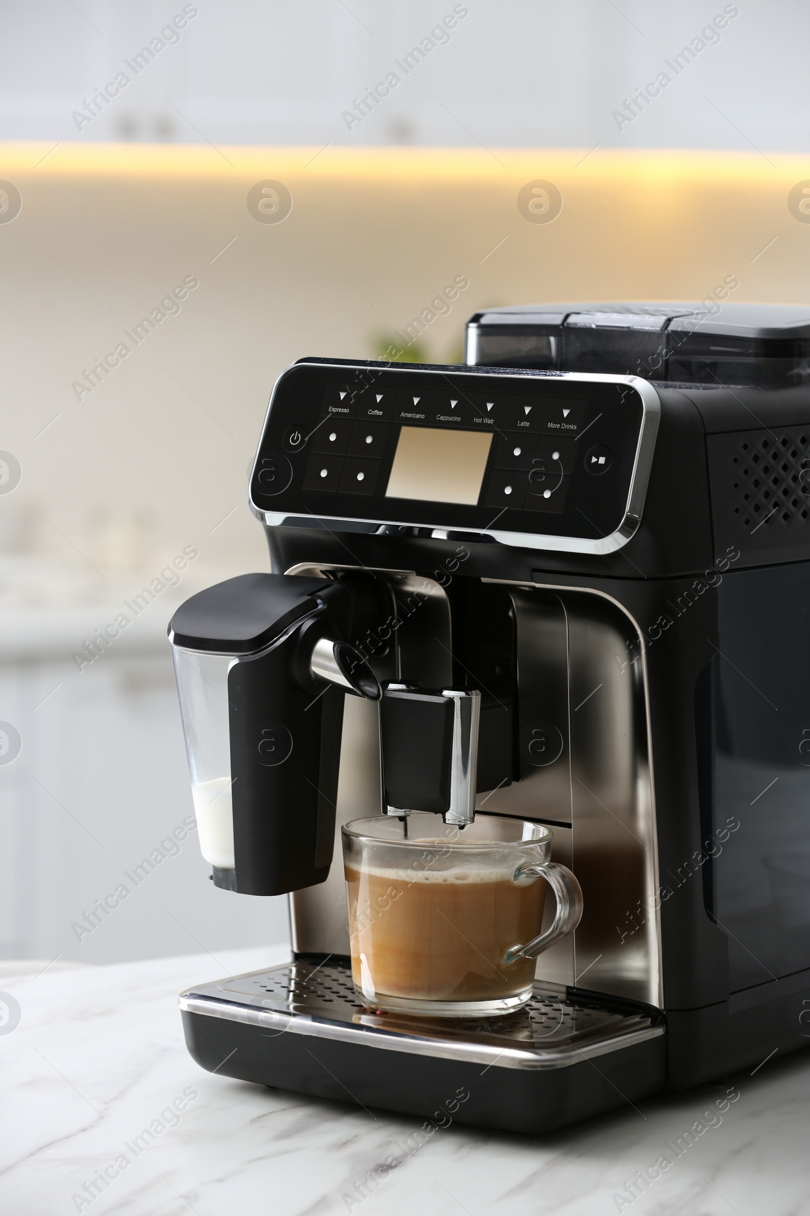 Photo of Modern espresso machine and glass cup of coffee with milk on white marble countertop in kitchen