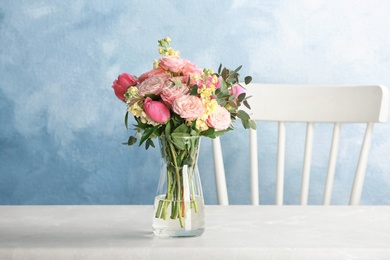 Vase with bouquet of beautiful flowers on table