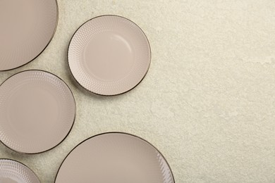 Beautiful ceramic plates on beige table, flat lay. Space for text