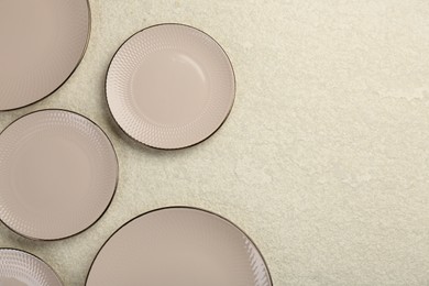 Photo of Beautiful ceramic plates on beige table, flat lay. Space for text