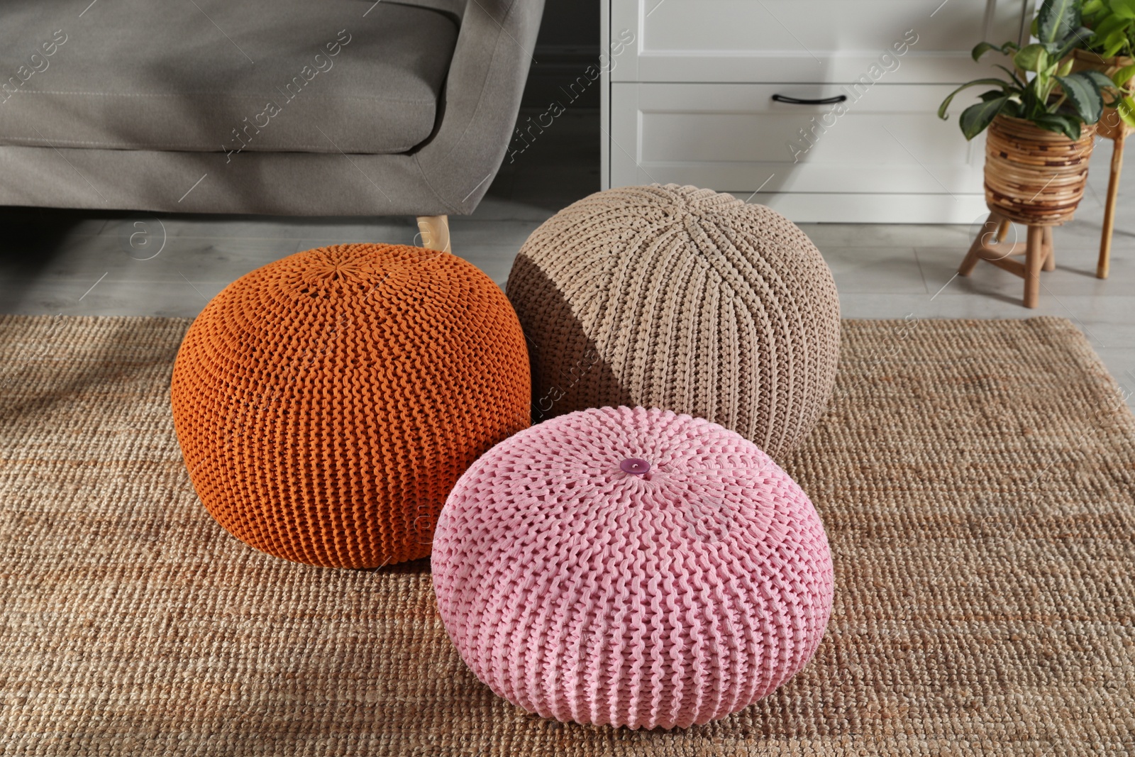 Photo of Stylish knitted poufs in room. Home design