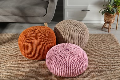 Stylish knitted poufs in room. Home design