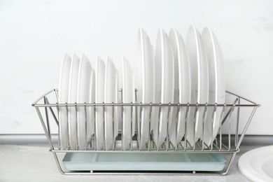 Different clean plates in dish drying rack on kitchen counter