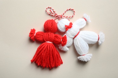 Traditional martisor shaped as man and woman on light background, top view. Beginning of spring celebration