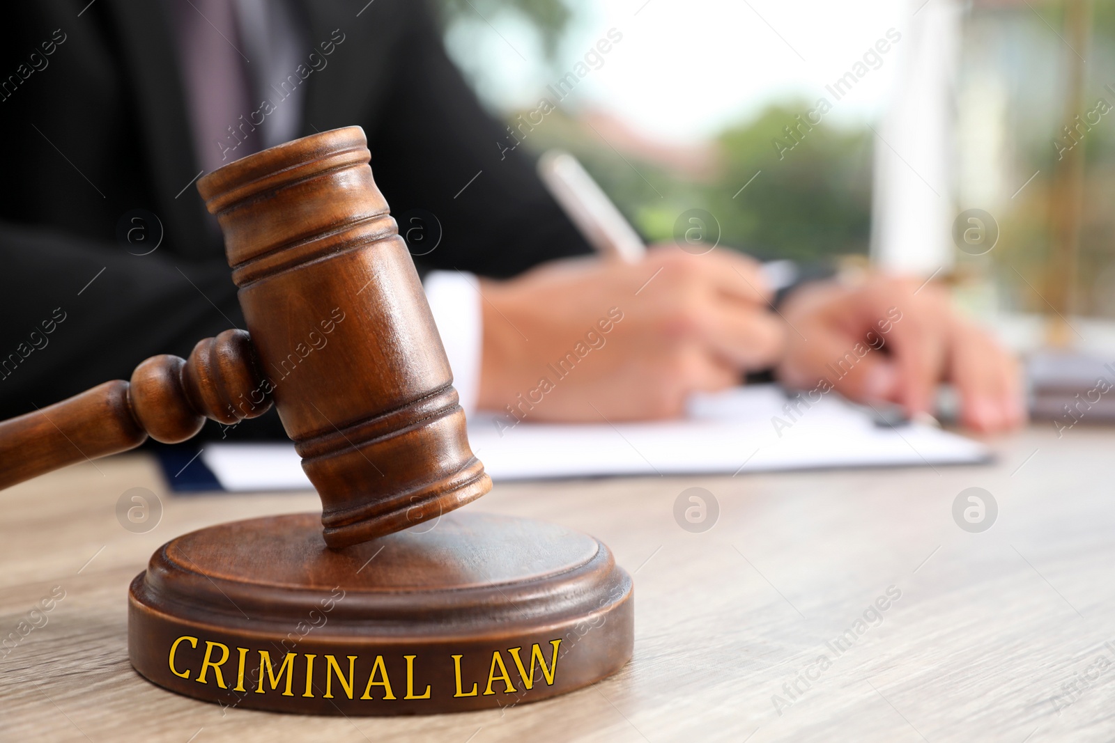 Image of Judge with gavel at wooden table indoors, closeup. Criminal law concept 