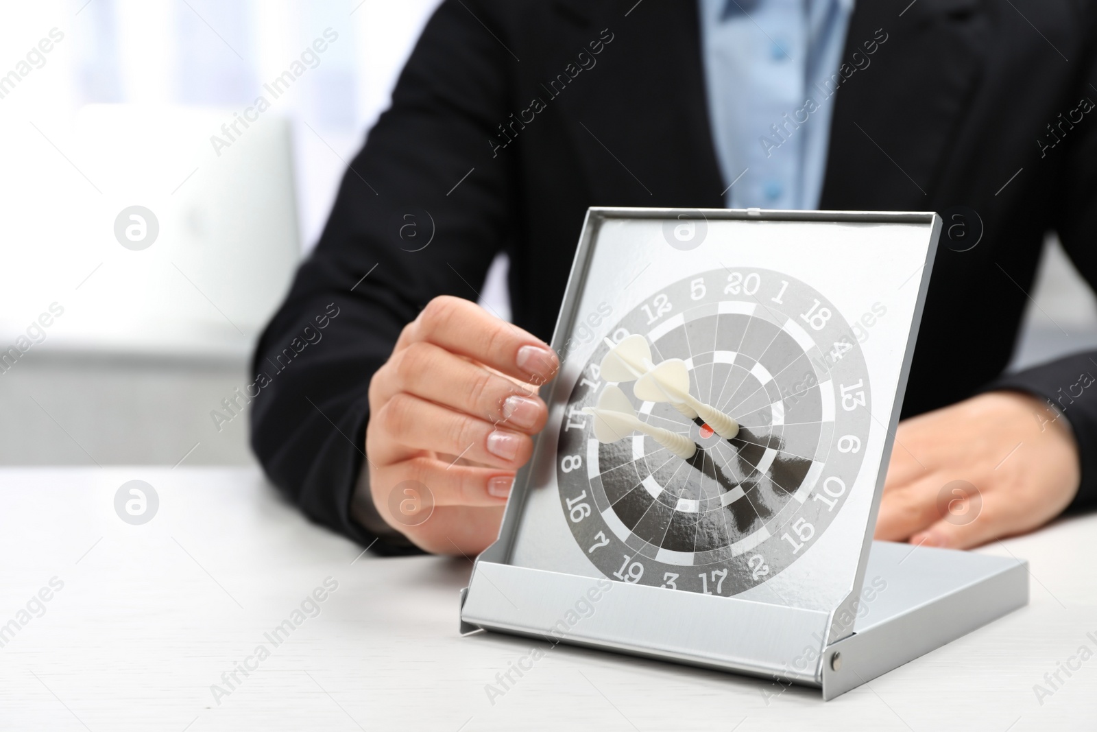 Photo of Woman with darts at table. Business trainer concept