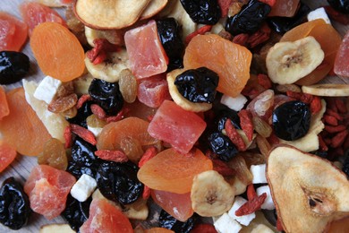 Different tasty dried fruits on wooden table, flat lay