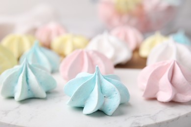 Tray with tasty meringue cookies on table