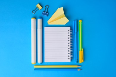 Photo of Paper plane and different school stationery on light blue background, flat lay with space for text. Back to school