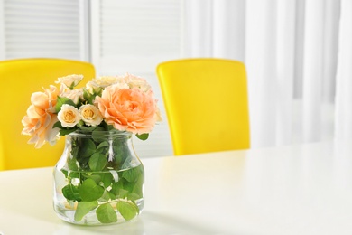 Photo of Vase with blooming flowers on table indoors