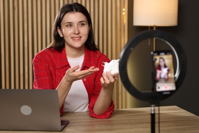 Photo of Smiling technology blogger recording video review about WI-FI extender at home