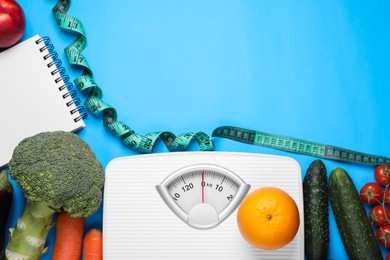 Photo of Scales, measuring tape, fresh fruits and vegetables on light blue background, flat lay with space for text. Low glycemic index diet