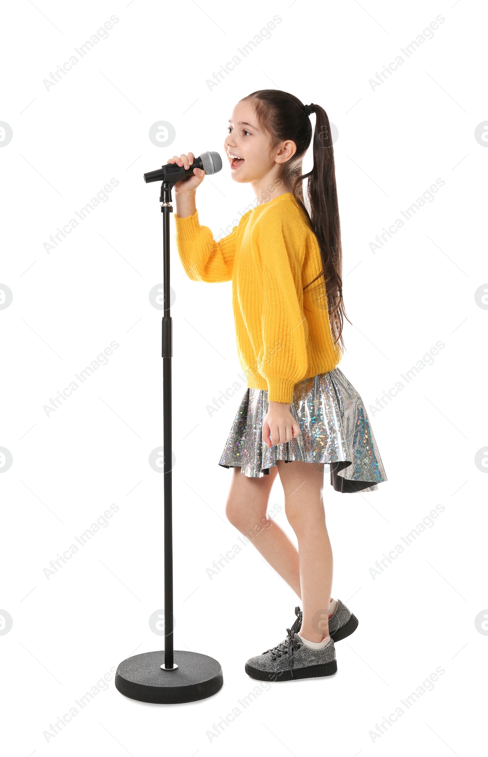 Photo of Little girl singing into microphone on white background