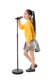 Little girl singing into microphone on white background