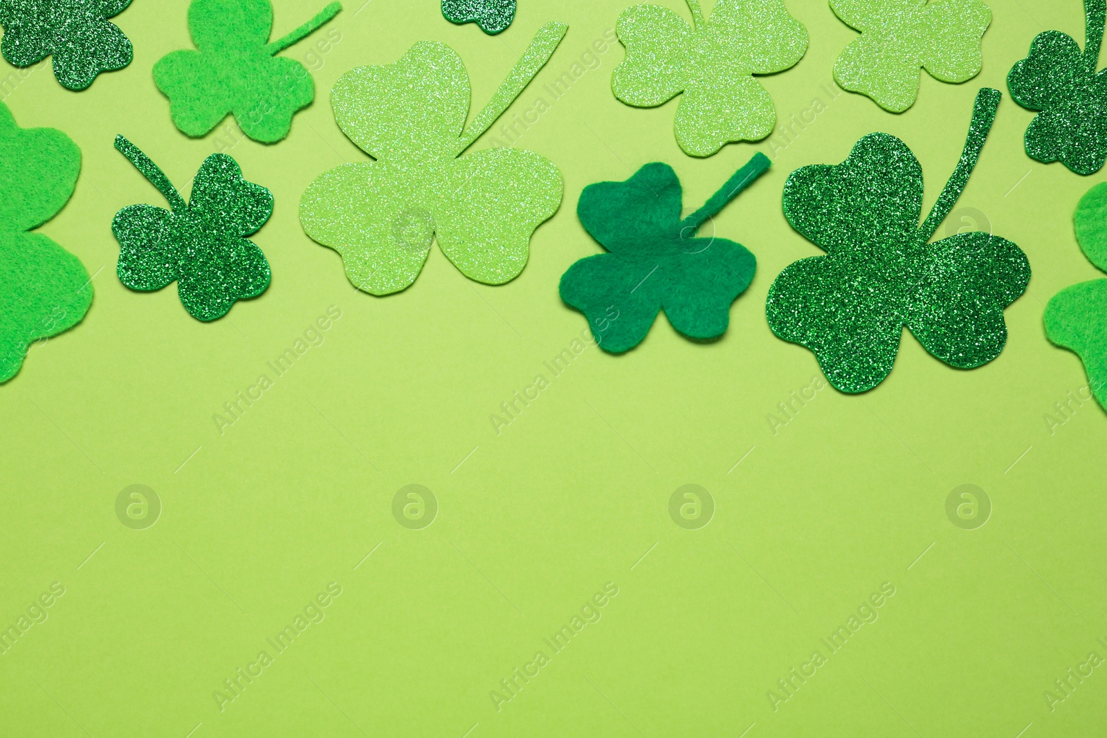 Photo of Flat lay composition with clover leaves on light green background, space for text. St. Patrick's Day celebration