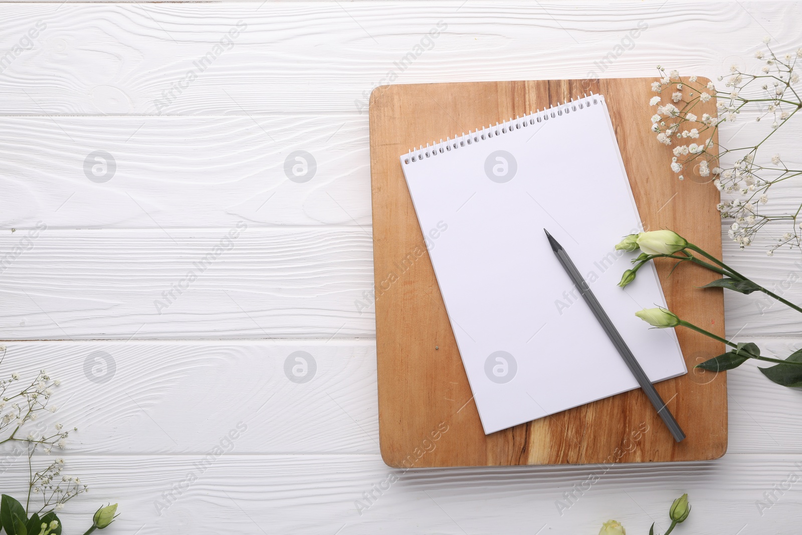 Photo of Guest list. Notebook, pencil and beautiful flowers on white wooden background, flat lay. Space for text