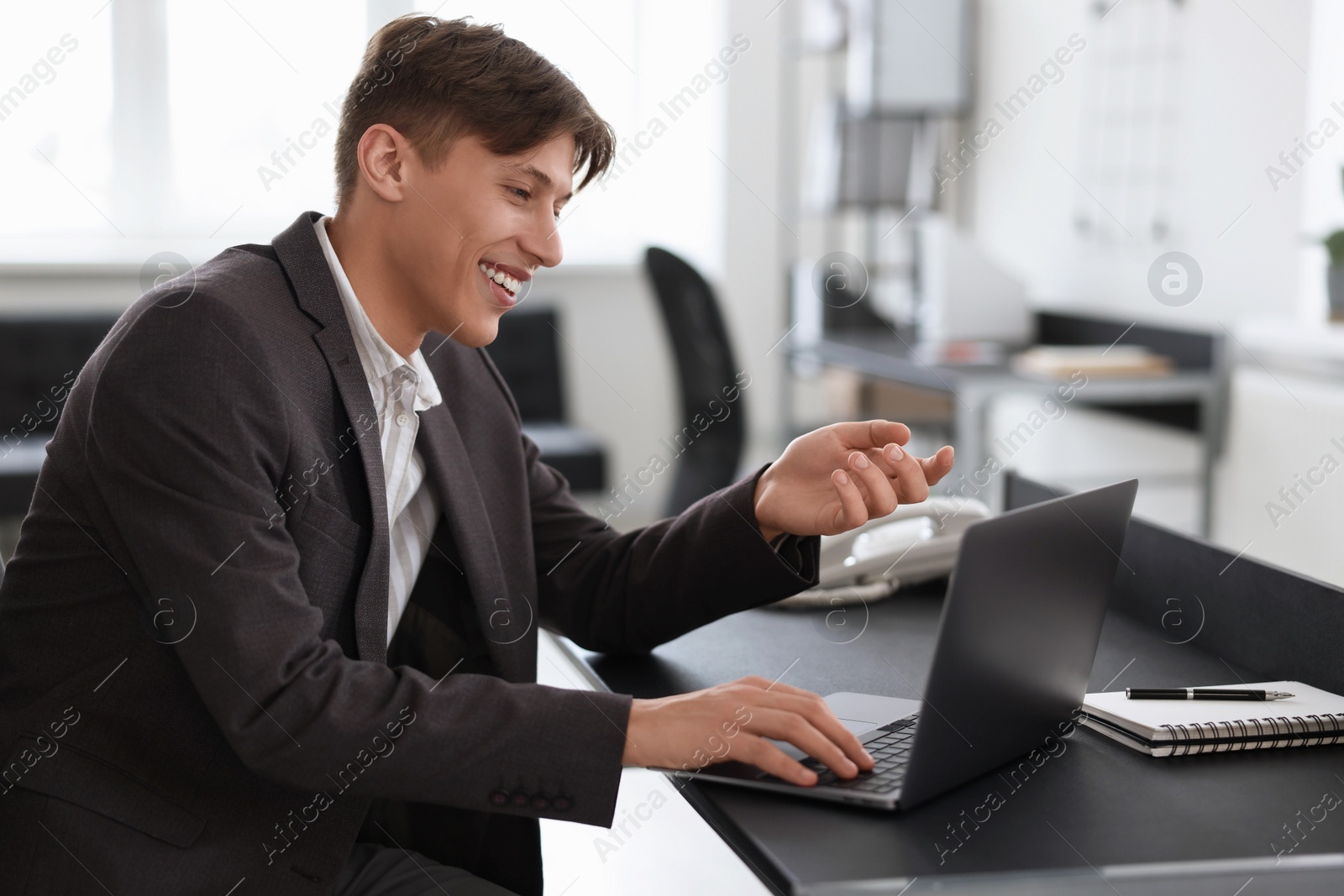 Photo of Man using video chat during webinar at table in office