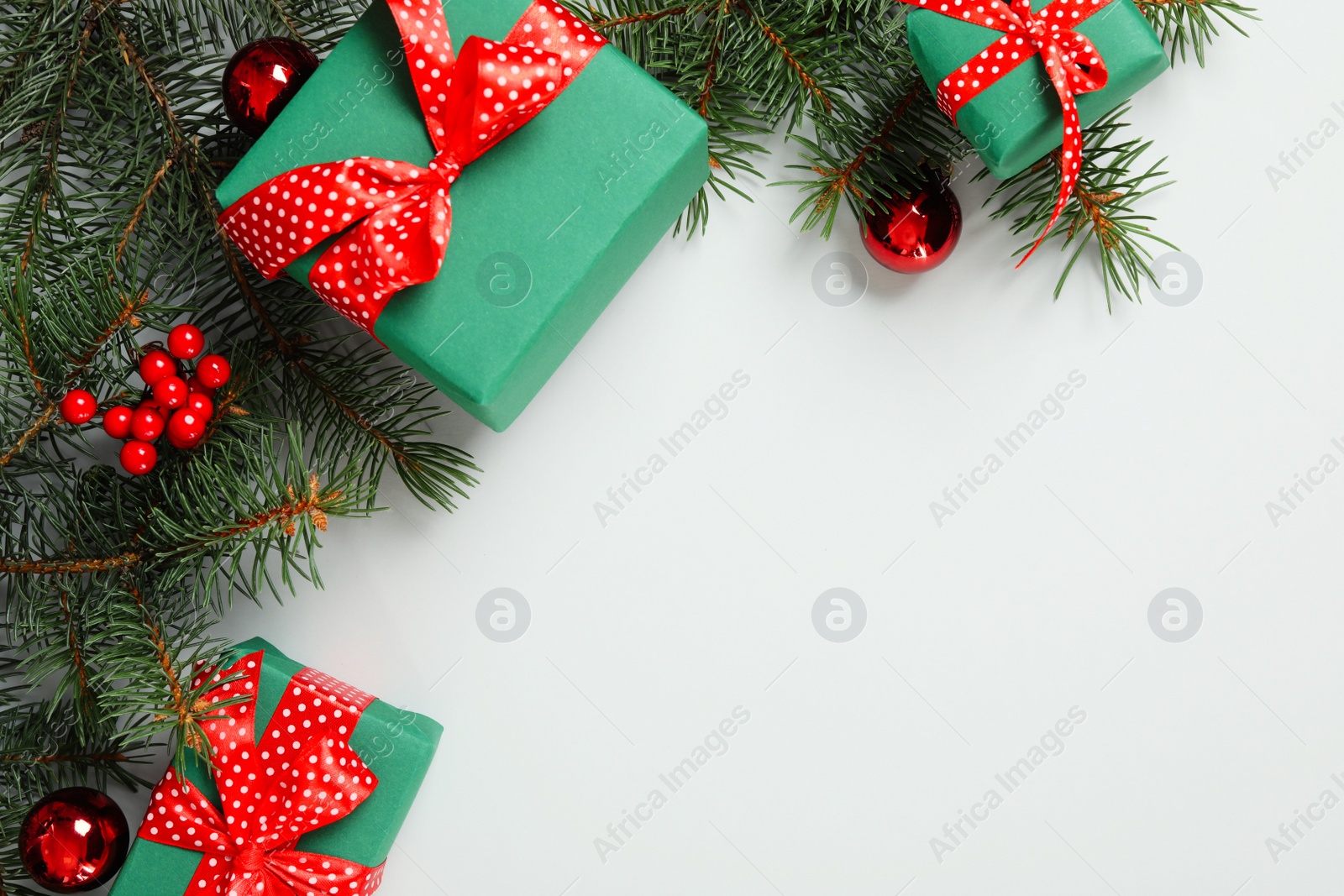 Photo of Gift boxes, Christmas balls and fir branches on grey background, flat lay. Space for text