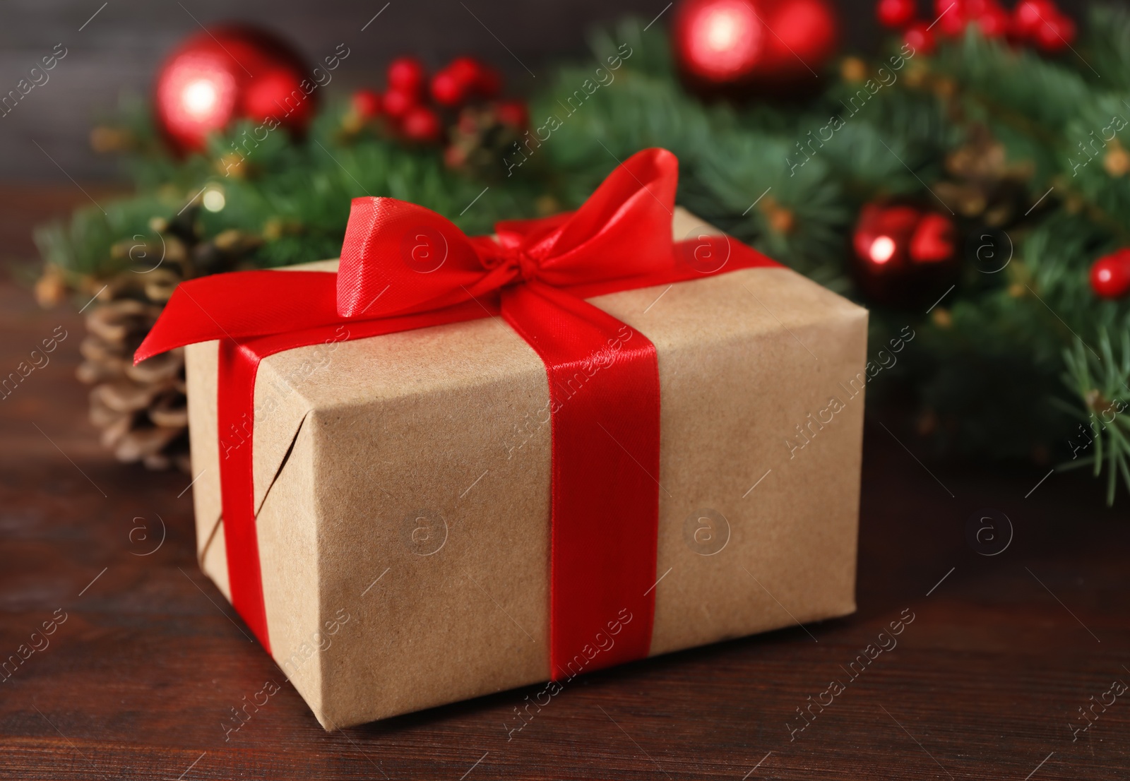 Photo of Christmas gift box on wooden table, closeup