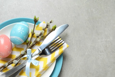 Photo of Festive Easter table setting with painted eggs on color background, top view. Space for text