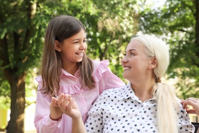 Photo of Mature woman with her little granddaughter in park