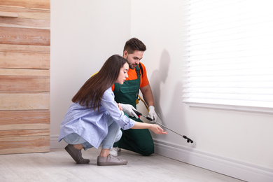 Photo of Woman showing insect traces to pest control worker at home