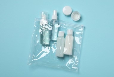 Cosmetic travel kit on light blue background, top view. Bath accessories