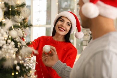 Happy couple decorating Christmas tree at home