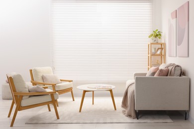 Photo of Stylish living room interior with sofa, coffee table and armchairs