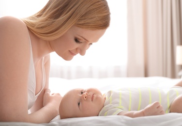 Photo of Mother with her little baby on bed at home